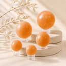 Orange Selenite spheres by Talk to Crystals, available in various sizes, featuring natural healing crystals for energy cleansing, creativity, joy, vitality, Sacral Chakra healing, and positive energy in India